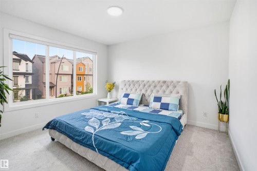 Bright room featuring a large window, neutral wall paint, and light-colored carpet flooring - 2508 193 Street, Edmonton, AB 