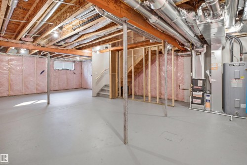 Unfinished basement with painted concrete flooring, visible framing, and insulation - 2508 193 Street, Edmonton, AB 