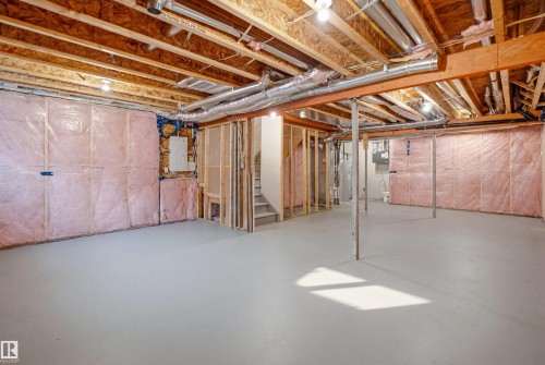Unfinished basement space featuring exposed wood joists and structural beams, insulated wall framing, concrete flooring, and visible ductwork - 2508 193 Street, Edmonton, AB 