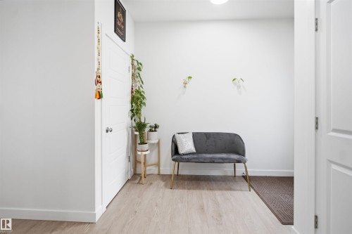Entryway featuring light wood-finish flooring, white paneled doors, and crisp white walls - 2508 193 Street, Edmonton, AB 