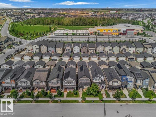 Residential street with varied architectural styles, green spaces, and a nearby commercial building - 2852 Duke Crescent, Edmonton, AB 