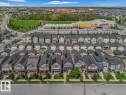 Residential street with varied architectural styles, green spaces, and a nearby commercial building - 2852 Duke Crescent, Edmonton, AB 