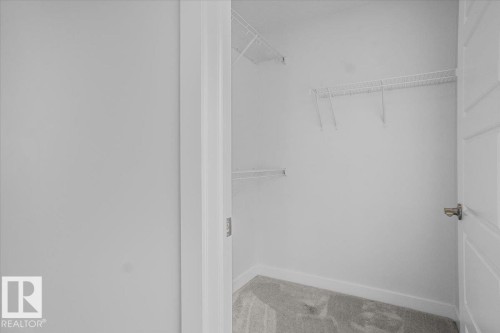 Walk-in closet featuring wire shelving, white painted walls, and light gray carpet flooring - 2852 Duke Crescent, Edmonton, AB 