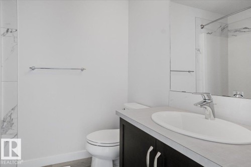 Bathroom vanity featuring a vessel sink, single-handle chrome faucet, and dark wood-finish cabinetry - 2852 Duke Crescent, Edmonton, AB 