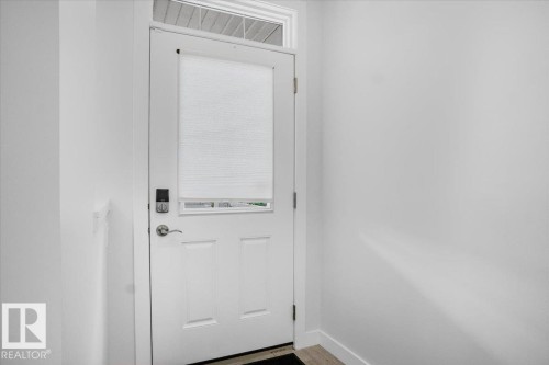 White paneled door with frosted glass insert and transom window - 2852 Duke Crescent, Edmonton, AB 