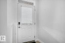 White paneled door with frosted glass insert and transom window - 2852 Duke Crescent, Edmonton, AB 