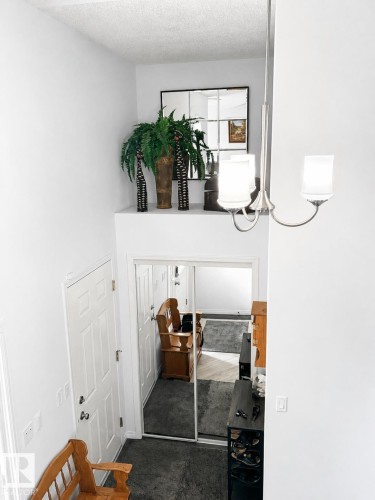 Entryway featuring a white paneled door, mirrored closet doors, and overhead lighting - 5006 53 Avenue, Cold Lake, AB 