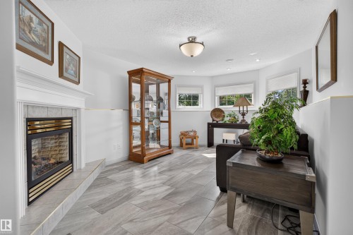 Living area featuring a tiled fireplace with a mantel, ceiling-mounted lighting, recessed lighting, and multiple windows - 5006 53 Avenue, Cold Lake, AB 