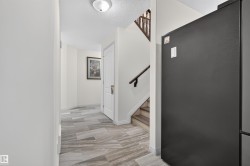Hallway with light-colored walls and patterned tile flooring - 