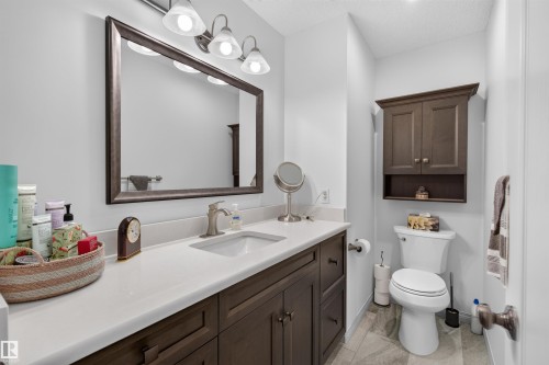 Bathroom featuring a single basin vanity with a light-colored countertop and dark wood-finish cabinetry - 5006 53 Avenue, Cold Lake, AB 
