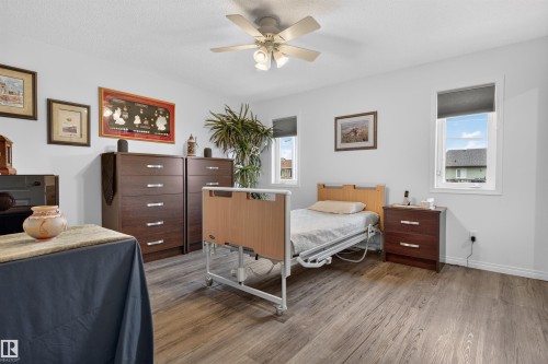 Spacious room featuring wood-finish flooring, white walls, and a ceiling fan with integrated lighting - 5006 53 Avenue, Cold Lake, AB 