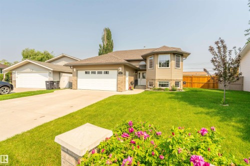 Bungalow-style residence featuring a bay window, attached garage, and light-toned siding - 5006 53 Avenue, Cold Lake, AB 