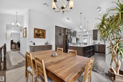 Spacious open-concept kitchen and dining area featuring vaulted ceilings - 