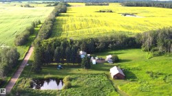 Looking toward the west the dugout/ pond, garden area, garage and barn compliment this upgraded home - 
