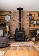 Central wood-burning stove with a brick surround and hearth - 