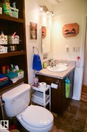 Bathroom vanity with a white basin sink, polished chrome faucet, and a stone-finish countertop - 