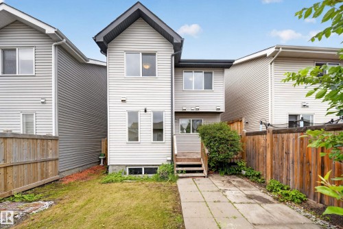 Rear exterior featuring light-colored siding, a multi-level wood deck, and a pitched roofline - 227 Cy Becker Blvd, Edmonton, AB 