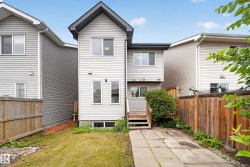 Rear exterior featuring light-colored siding, a multi-level wood deck, and a pitched roofline - 