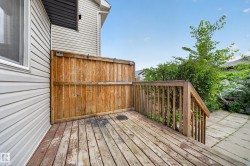 Wood deck with a privacy fence, wood railing, and a patio area - 