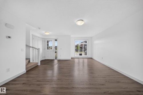 Open concept living area featuring wood-finish flooring and white baseboards - 227 Cy Becker Blvd, Edmonton, AB 