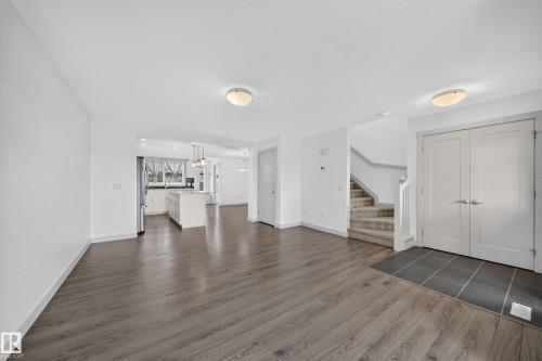 Open-concept living area with wood-finish flooring, recessed lighting, and a neutral color palette - 227 Cy Becker Blvd, Edmonton, AB 