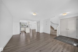 Open-concept living area with wood-finish flooring, recessed lighting, and a neutral color palette - 