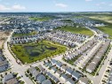 Expansive aerial capturing a suburban development featuring a central wetland area with walking paths - 227 Cy Becker Blvd, Edmonton, AB 