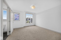 Carpeted room with white walls and a contemporary flush-mount ceiling light fixture - 