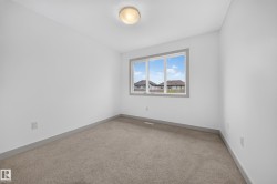 Bright room featuring neutral carpeting, white walls, and a window with grey trim - 