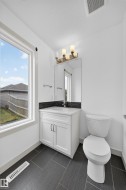 White vanity with integrated sink, chrome faucet, and dark tile backsplash - 