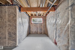 Unfinished interior space featuring exposed wood framing, ceiling joists, and a concrete floor - 