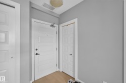 Entryway featuring light wood-finish flooring, white paneled doors, and painted walls - 