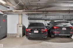 Concrete parking garage with exposed ceiling pipes and concrete support pillars - 