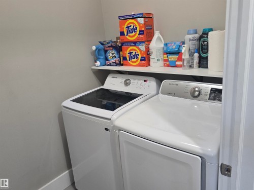Dedicated laundry area featuring a white top-load washing machine and a white front-load dryer - 1019 175 Street, Edmonton, AB 