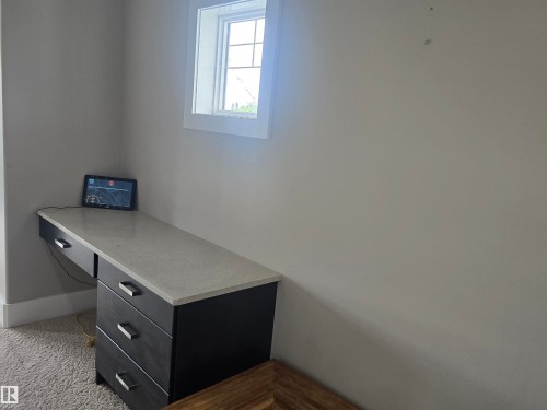 Built-in desk featuring a light-toned countertop and dark wood-finish cabinetry - 1019 175 Street, Edmonton, AB 