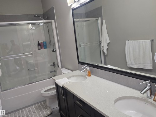 Bathroom featuring a dual vanity with light-toned countertops, undermount sinks, and chrome faucets - 1019 175 Street, Edmonton, AB 