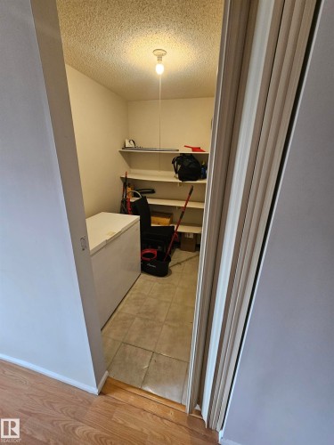 Utility room with ample shelving, ceiling-mounted light fixture, and tile flooring - 10838 108 Street Nw, Edmonton, AB 