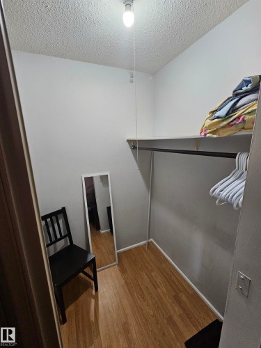 Spacious closet featuring wood-finish flooring, built-in shelving, and a clothing rod for ample storage - 10838 108 Street Nw, Edmonton, AB 
