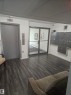 Lobby featuring dark wood-finish flooring, an elevator, wall-mounted mailboxes, and glass entry doors - 10838 108 Street Nw, Edmonton, AB 