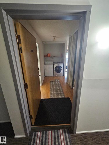 Dedicated laundry area featuring wood-finish flooring and integrated shelving - 10838 108 Street Nw, Edmonton, AB 