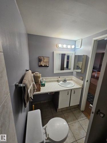 Bathroom featuring a white toilet, light gray walls, and tiled flooring - 10838 108 Street Nw, Edmonton, AB 
