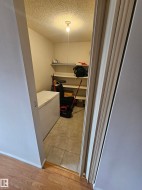 Utility room with ample shelving, ceiling-mounted light fixture, and tile flooring - 