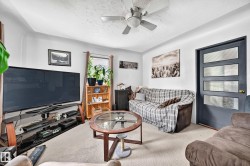 Living area featuring neutral wall tones, textured ceiling, and carpet flooring - 