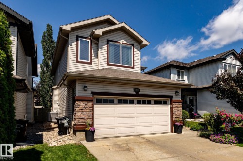 Two-story residence featuring light-colored siding with dark trim accents - 5820 7 Avenue Sw, Edmonton, AB - Outdoor