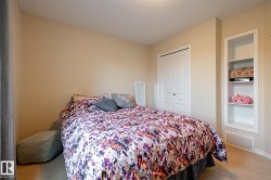 Bedroom featuring neutral wall paint, carpet flooring, a bifold closet door, and built-in shelving - 