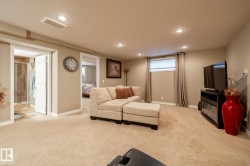 Spacious recreation room featuring recessed lighting, plush carpeting, and multiple doorways - 