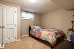 Carpeted bedroom with a window, white window blinds, and patterned curtains - 
