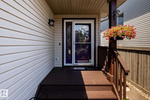 Front entry porch with dark wood-finish decking and railing - 5820 7 Avenue Sw, Edmonton, AB - Outdoor With Deck Patio Veranda With Exterior
