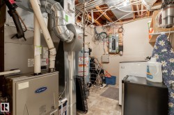 Utility area with a Carrier brand furnace, water heater, and electrical panel - 