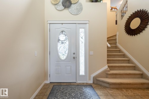 Entryway featuring a white door with an oval-shaped glass insert and a frosted sidelight - 5820 7 Avenue Sw, Edmonton, AB - Indoor Photo Showing Other Room